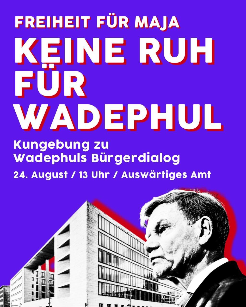 Plakat mit lila Hintergrund und weiß-rotem Text 'Freiheit für Maja Keine Ruh für Wadephul'. Schwarz-weiße Illustration eines modernen Bürogebäudes und Johann Wadephul im Anzug.
